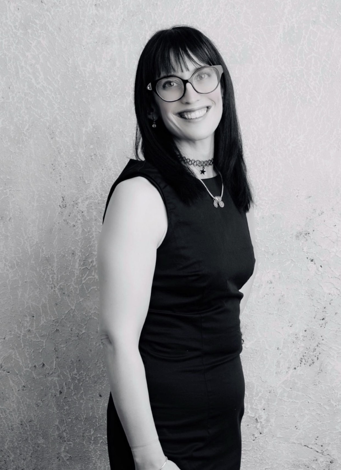 Janine Havanci, a black-and-white portrait against a pale wall